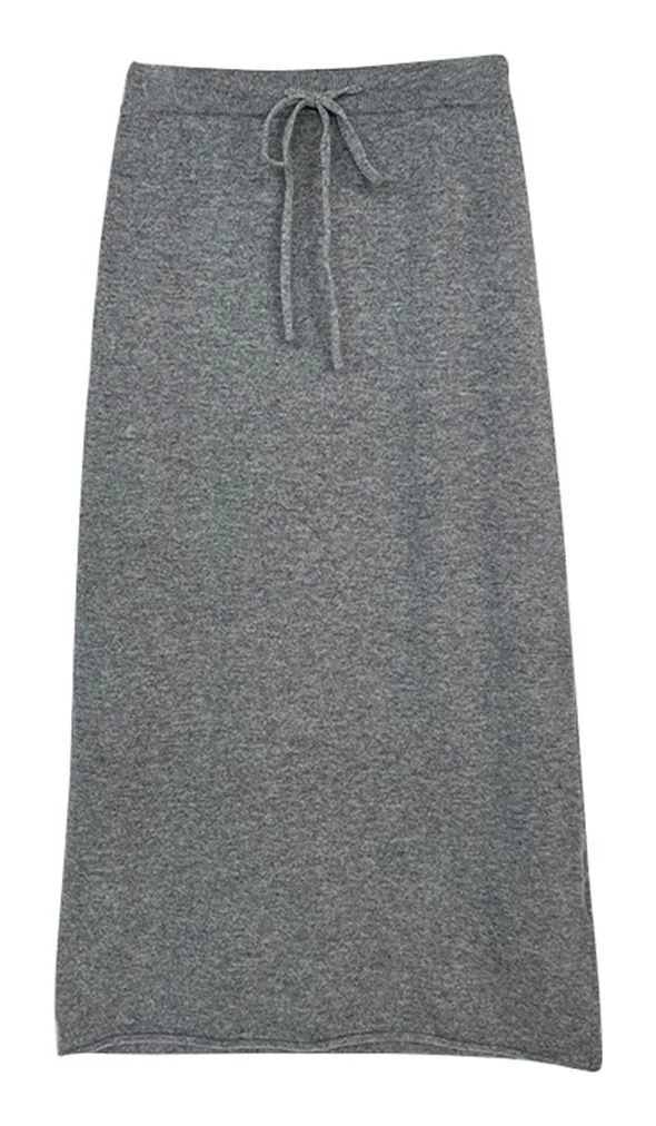 All-Wool Knit Skirt — A grey knitted midi skirt with a drawstring waist, shown flat on white, worn full length, and pooled over the legs