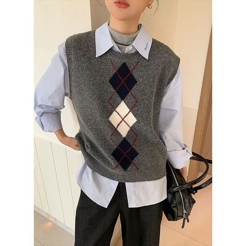 Argyle Knit Vest — A grey knitted vest with a column of navy and cream diamonds down the front, worn over a blue poplin shirt