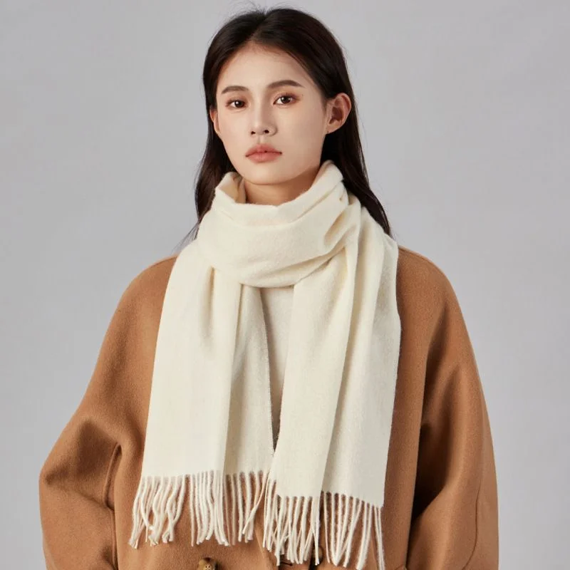 Long Wool Fringe Scarf — A long cream wool scarf with a fringed end, worn over a camel coat